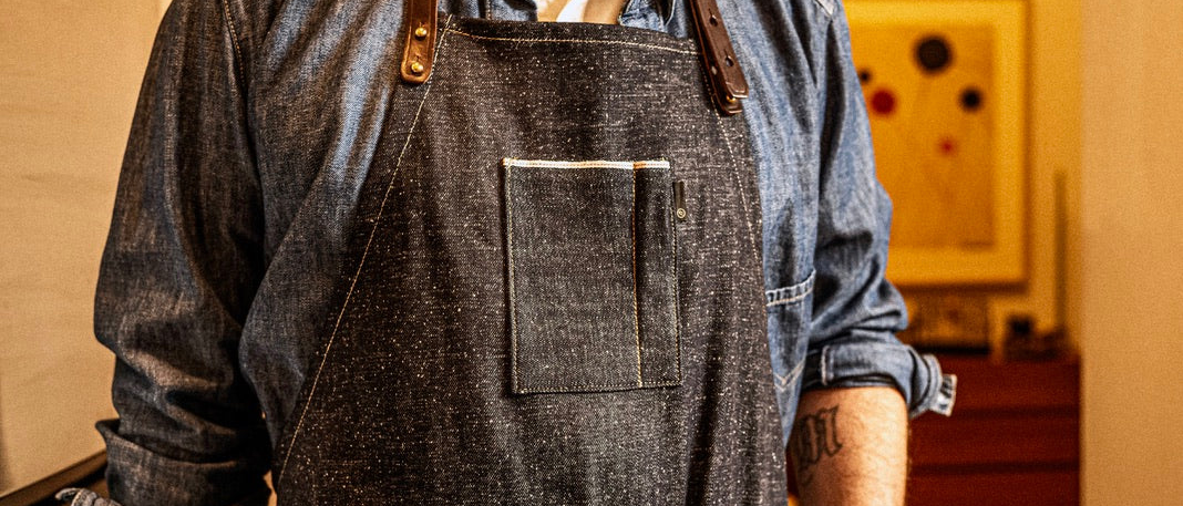 Person wearing a denim apron in a workshop setting